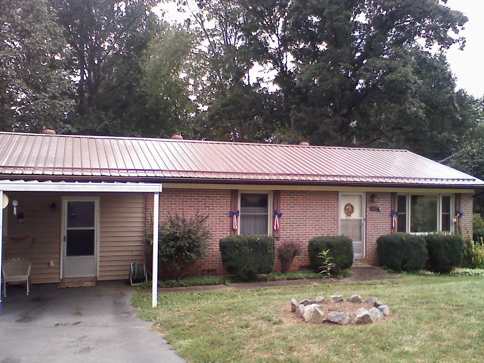 Bronze metal roof and carport on a brick ranch home — Roof Repair work by our crew in Roebling
